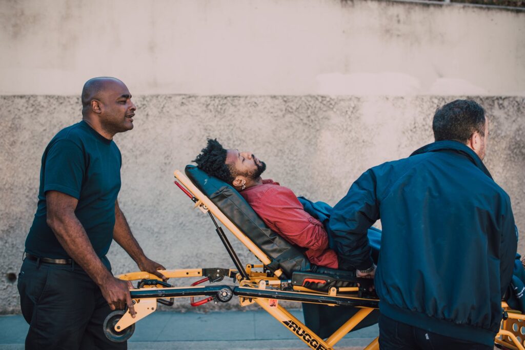 paramedics pushing man on stretcher